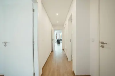 a long hallway with white walls and wooden floors at Modern Bonfim by Hosty in Porto