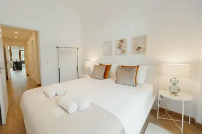 a white bedroom with a large white bed with towels on it at Modern Bonfim by Hosty in Porto