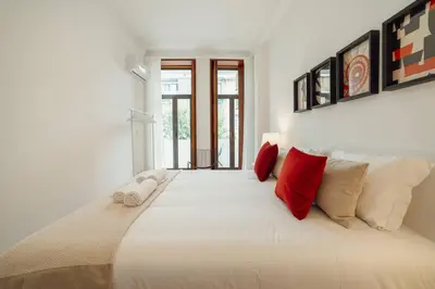 a bedroom with a large white bed with red pillows at Modern Bonfim by Hosty in Porto