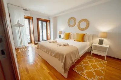 a bedroom with a white bed and a mirror on the wall at Bonfim Vintage by Hosty in Porto