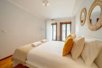 a bedroom with a large bed with a mirror on the wall at Bonfim Vintage by Hosty in Porto