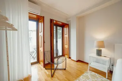 a room with a chair and a table and a window at Bonfim Vintage by Hosty in Porto