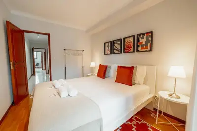 a bedroom with a white bed with two towels on it at Bonfim Vintage by Hosty in Porto