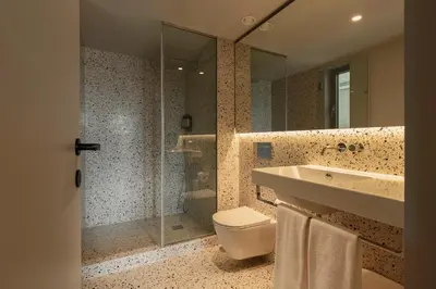 a swimming pool in a yard next to a stone wall at Vandoma Serviced Apartments in Porto