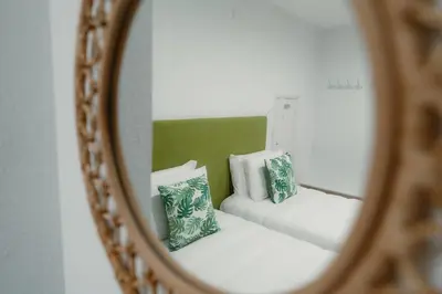 a mirror reflection of two pillows on a couch at Douro Garden - Authentic Portuguese Guesthouse in Vila Nova de Gaia