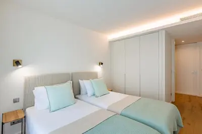 a bedroom with a white bed with blue pillows at Renovato Prestige in Porto