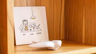 a drawing of a person sitting at a table with a drink at Bolhão Charming Apartment by LovelyStay in Porto