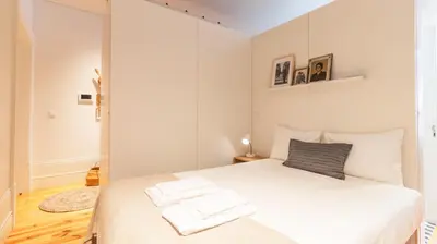 a bedroom with a white bed with two towels on it at Bolhão Charming Apartment by LovelyStay in Porto