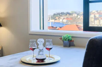 two glasses of wine on a table with a window at MyRiverPlace N 1 River View Porto apartments in Vila Nova de Gaia