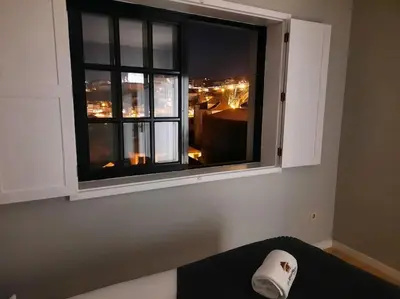 a window with a view of a city at night at MyRiverPlace N 1 River View Porto apartments in Vila Nova de Gaia