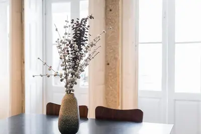 a vase with flowers in it sitting on a table at L'Atelier by Upperground in Porto