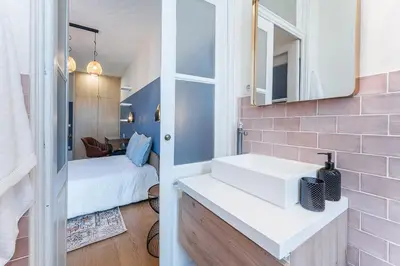 a bathroom with a white sink and a bedroom at L'Atelier by Upperground in Porto