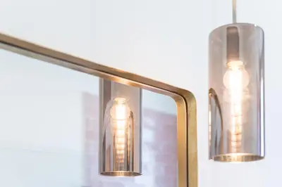 a mirror with two lights on top of it at L'Atelier by Upperground in Porto