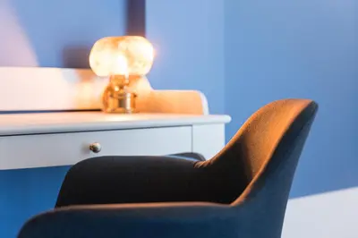 a black chair sitting next to a desk with a lamp at L'Atelier by Upperground in Porto