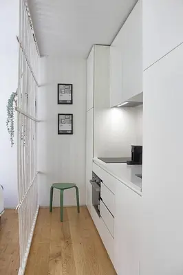 a kitchen with white cabinets and a green stool at Classy Urban Life Studio Oporto in Porto