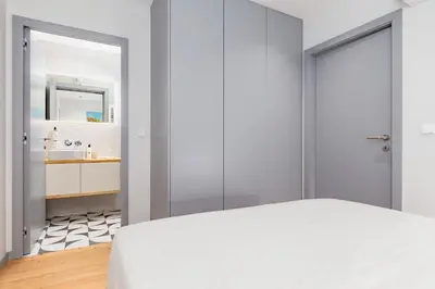 a bedroom with a white bed and a bathroom at Almada 505 - Premium Flat in Porto