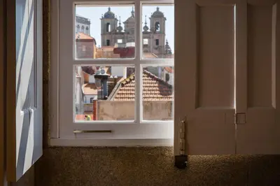 an open window with a view of a city at FLORES 36 by YoursPorto in Porto