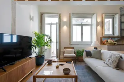 a living room with a white couch and a tv at BOUTiQUE Rentals- LOvPORTO Ribeira historic center in Porto