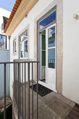 a white door on a building with a balcony at BOUTiQUE Rentals- LOvPORTO Ribeira historic center in Porto