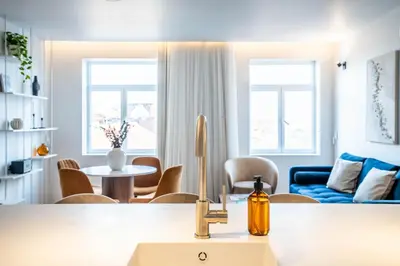 a kitchen and living room with a sink and a table at Penthouse with City Views - Almada 551 in Porto