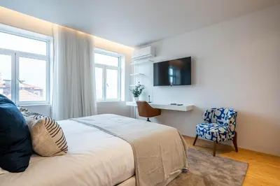 a bedroom with a bed and a desk and a chair at Penthouse with City Views - Almada 551 in Porto