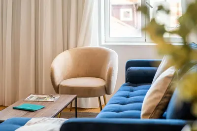 a living room with a chair and a blue couch at Penthouse with City Views - Almada 551 in Porto