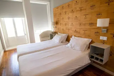 a bedroom with a large white bed with a wooden wall at Decanting Porto House in Porto