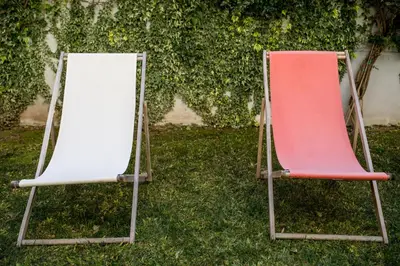 two chairs sitting in the grass next to a mirror at Decanting Porto House in Porto