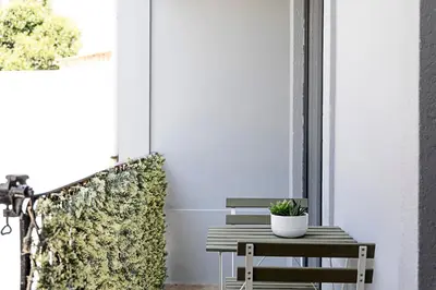 a wooden bench sitting on a porch with a plant at Lovely Flat Marquês in Porto