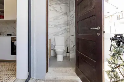 a bathroom with a toilet and a wooden door at Lovely Flat Marquês in Porto