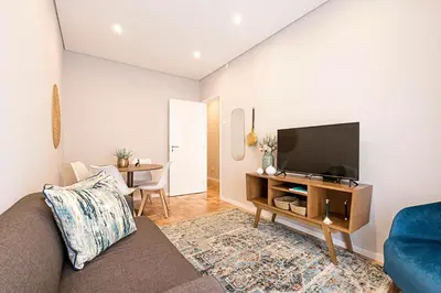 a living room with a couch and a flat screen tv at Lovely Flat Marquês in Porto