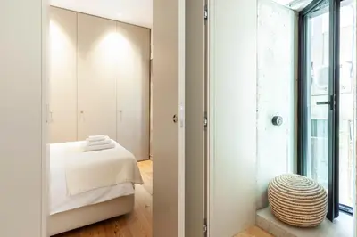 a bedroom with white walls and a bed and a window at Perfect retreat in the center of Porto in Porto