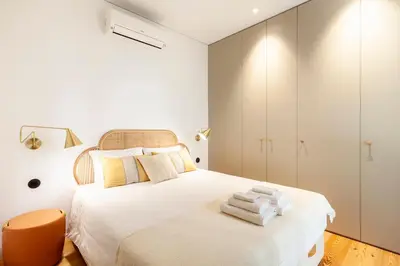 a bedroom with a white bed with towels on it at Perfect retreat in the center of Porto in Porto