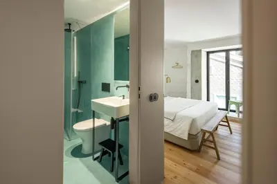 a bathroom with a sink and a bed in a room at Elegant apartment in the historical center of Porto in Porto