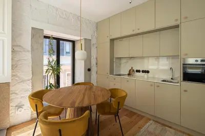 a kitchen with a wooden table and yellow chairs at Elegant apartment in the historical center of Porto in Porto