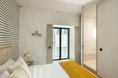a bedroom with a king sized bed and a window at Elegant apartment in the historical center of Porto in Porto