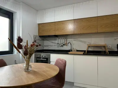 a kitchen with a table with a vase of flowers on it at Marinho's Oporto Apartments II in Porto