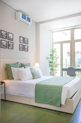 a white bedroom with a large bed and a window at Alegria Colour Apartments in Porto