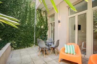 a patio with a table and chairs and a green wall at Alegria Colour Apartments in Porto