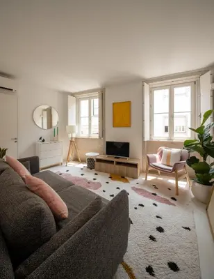 a living room with a couch and a tv at Cosy Minimalist duplex in Porto
