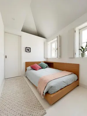 a bedroom with a bed and two windows at Cosy Minimalist duplex in Porto
