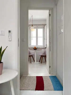 a white hallway with a red and blue rug at Cosy Minimalist duplex in Porto