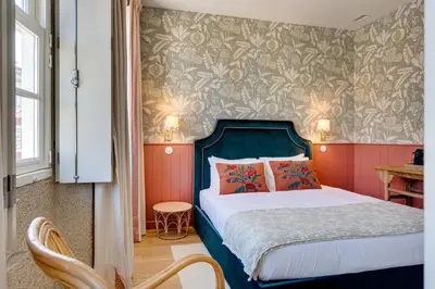 a bedroom with a bed with a blue head board at Lóios 74 Suites by DA'HOME in Porto