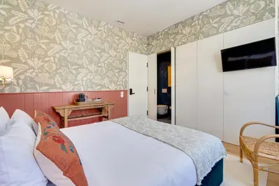 a bedroom with a bed and a tv on the wall at Lóios 74 Suites by DA'HOME in Porto