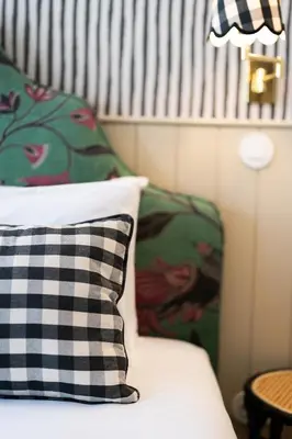 a bed with a black and white pillow and a table at Lóios 74 Suites by DA'HOME in Porto
