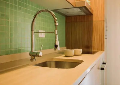 a kitchen with a sink and green tiles at D João IV Stay in Porto