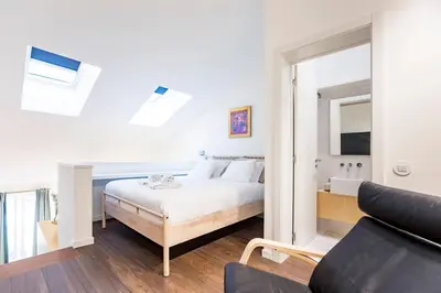a white bedroom with a bed and a mirror at GuestReady - Super cozy 1BDR apartment for 4pax in Porto