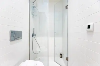 a white bathroom with a shower and a toilet at GuestReady - Super cozy 1BDR apartment for 4pax in Porto