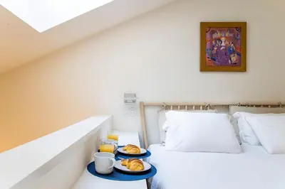 a bedroom with two plates of food on a bed at GuestReady - Super cozy 1BDR apartment for 4pax in Porto