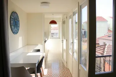 a hallway with a table and a clock on the wall at Oporto Trendy Apartments in Porto
